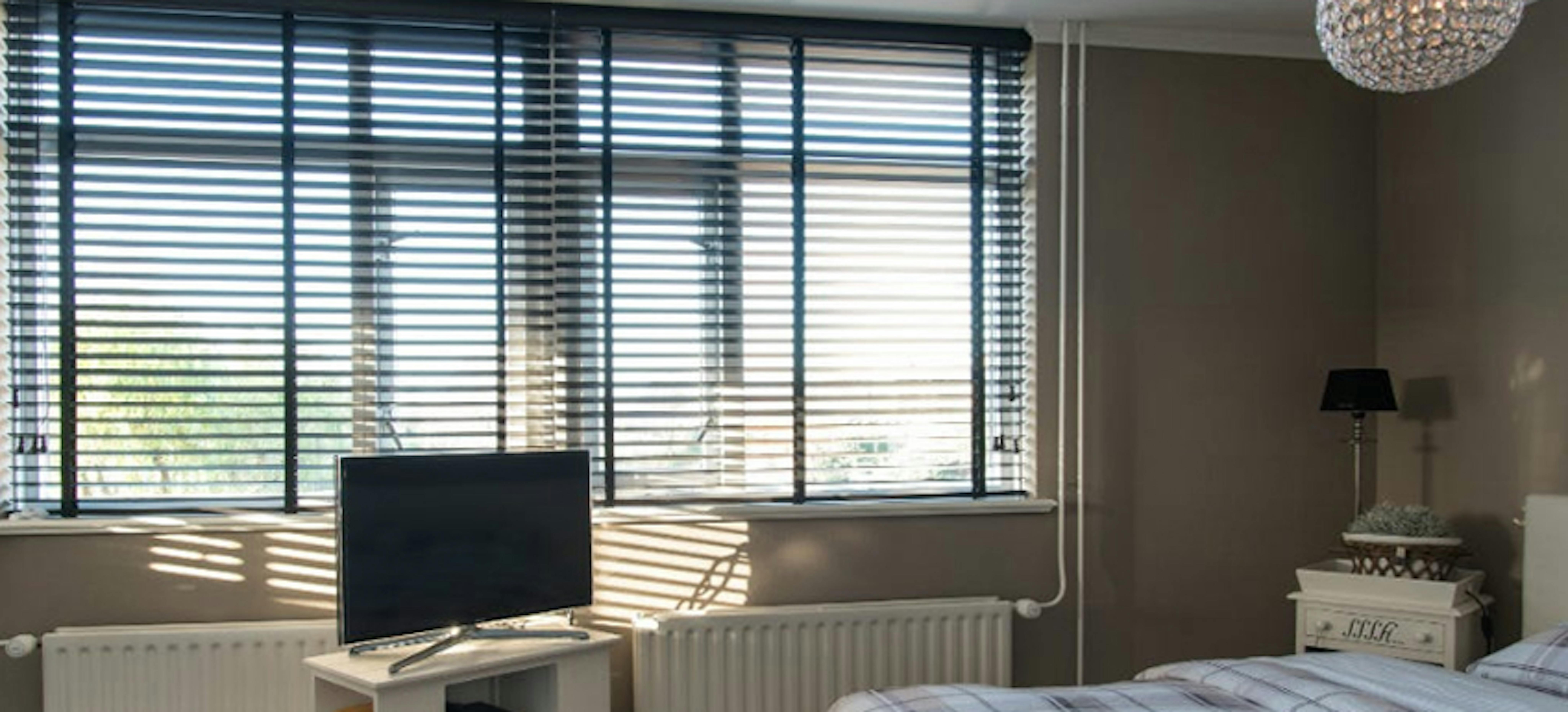 Houten jaloezieën in een landelijk interieur Houten jaloezieën in een landelijk interieur