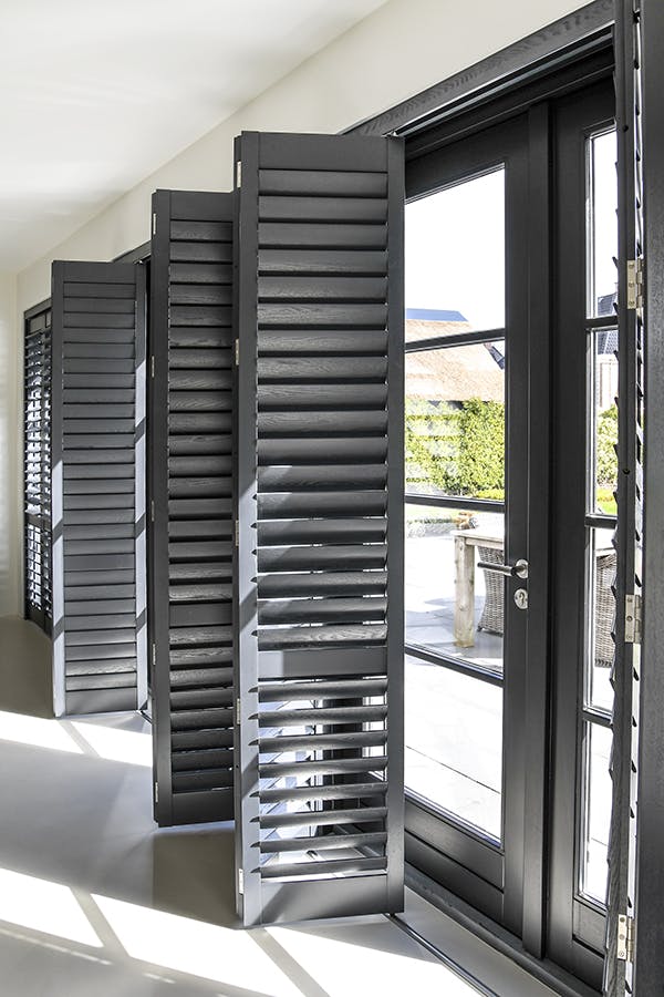 inhuis - zwarte shutters bij de achterdeur